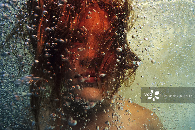 在充满气泡的游泳池中水下的女孩肖像图片素材