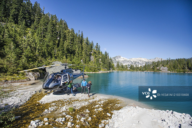 游客团乘直升机抵达湖边参加探险之旅图片素材