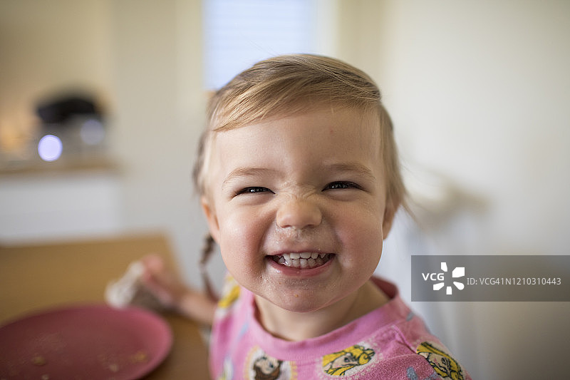 用餐时微笑的可爱女孩肖像图片素材