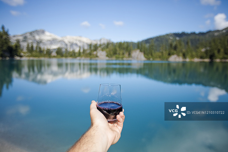 在山间湖泊享用一杯红酒图片素材