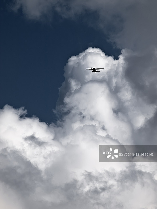 多云天空中的螺旋桨飞机图片素材