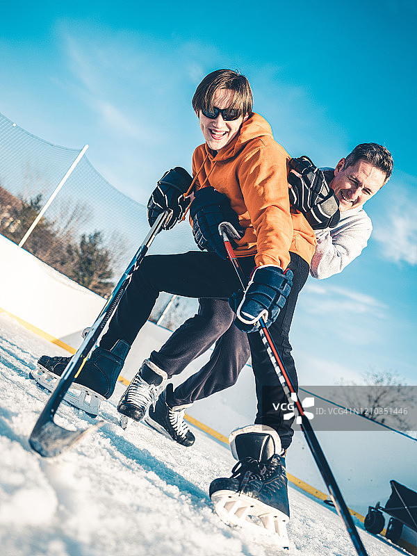 父子在户外打冰球图片素材