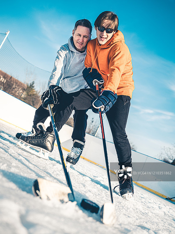 父子在户外打冰球图片素材