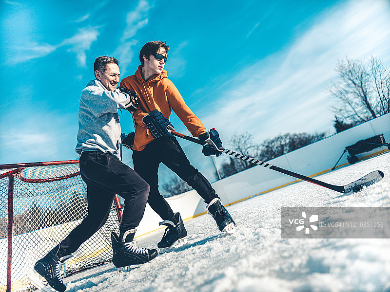 父子在户外打冰球图片素材