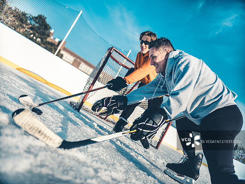 父子在户外打冰球图片素材