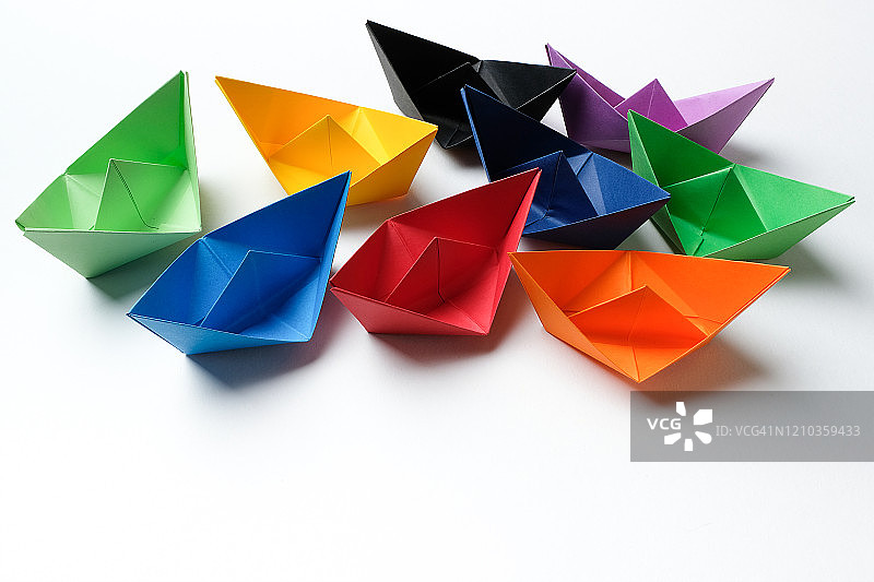 白色背景上的明亮彩色纸船，留白图片素材