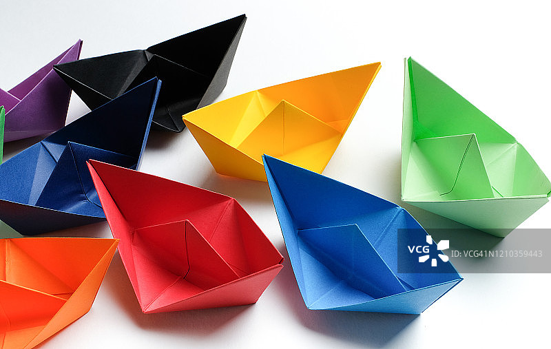 白色背景上的明亮彩色纸船，留白图片素材