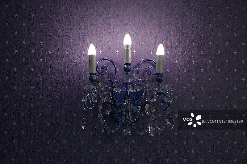 紫色壁纸背景上的水晶壁灯图片素材