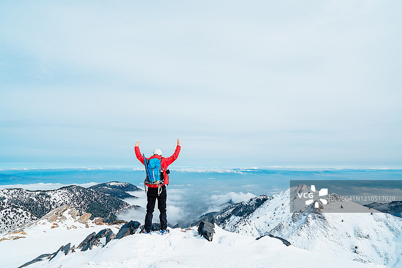 冬季，阿尔卑斯登山者在高原山顶做出和平手势图片素材