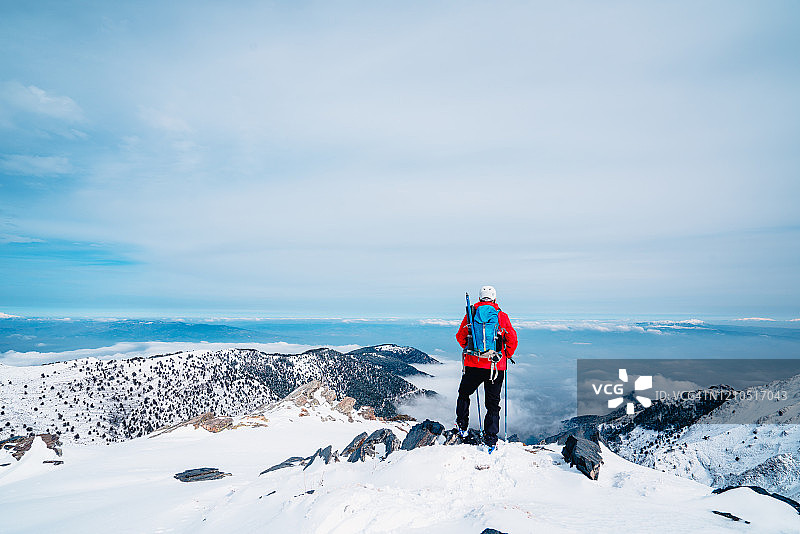 老年登山者在冬季高海拔山顶欣赏风景图片素材