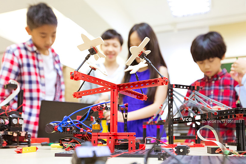 课桌旁的公园游乐设施模型与学生图片素材