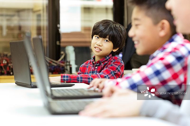 在课堂上用笔记本电脑学习编程的男学生图片素材