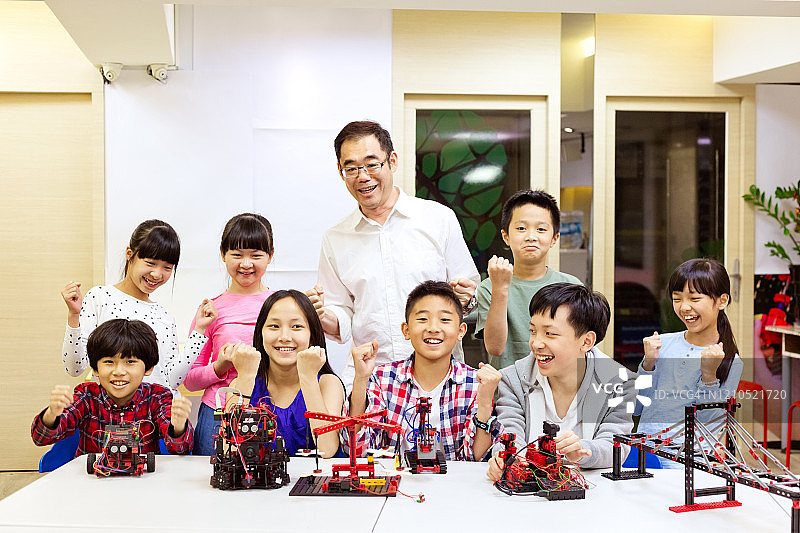 成功的老师和学生与机器人在一起图片素材