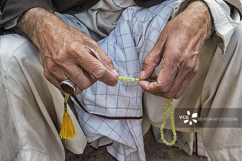 伊朗克尔曼穆扎法里清真寺内手持念珠的穆斯林男子，克尔曼省图片素材