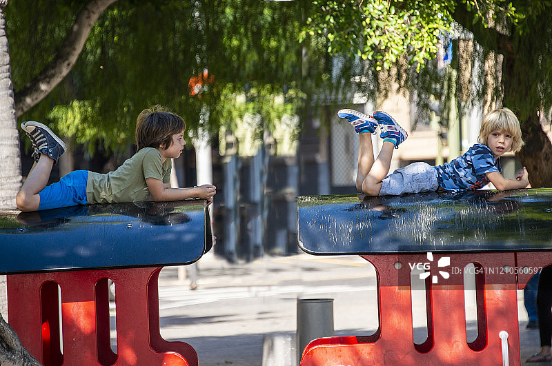 男孩们在西班牙特内里费岛圣克鲁斯一辆木制火车的车顶上图片素材
