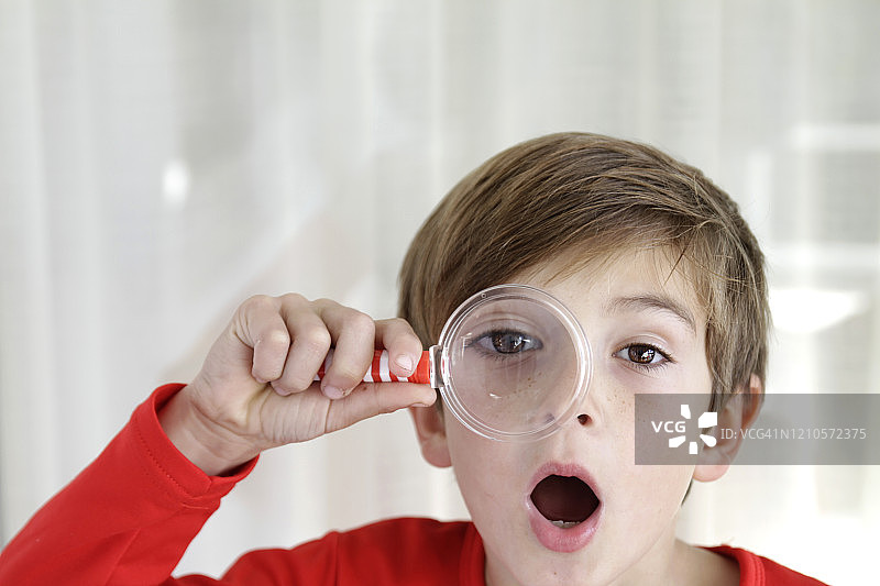 男孩用放大镜观察图片素材