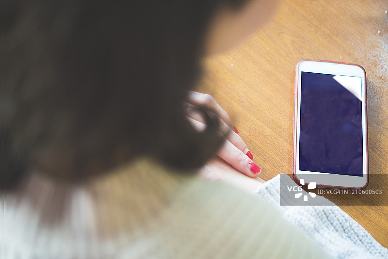 在桌旁使用智能手机的女人图片素材