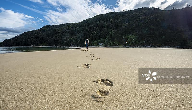 新西兰南岛塔斯曼亚伯塔斯曼国家公园斯蒂尔韦尔湾海滩上的年轻人脚印图片素材