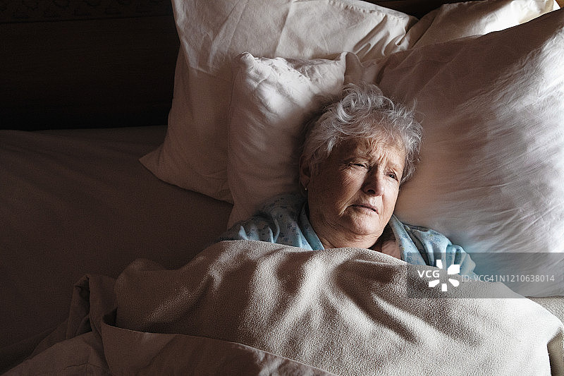卧床不起的生病老妇痛苦地望着远方图片素材