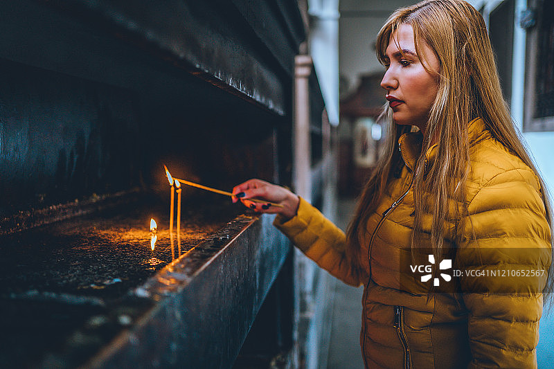 女人在教堂点燃蜡烛图片素材