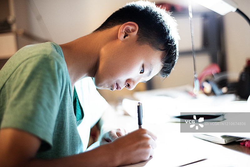在书桌上写作业的男孩图片素材