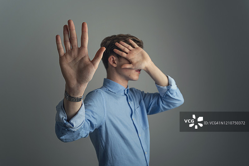 男人藏在手后图片素材