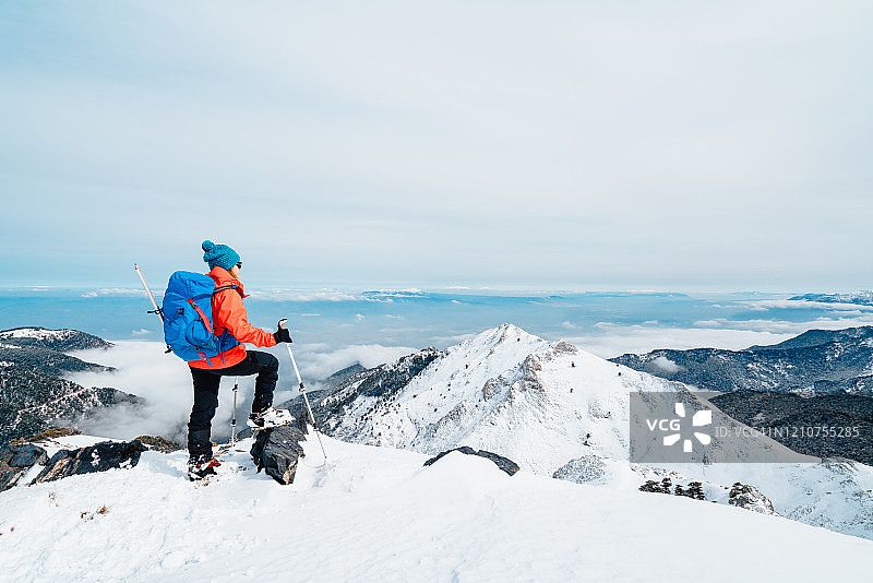 冬季站在高海拔山顶的美丽女登山者图片素材