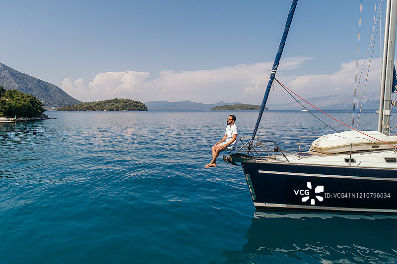 男子在帆船船头享受航海图片素材
