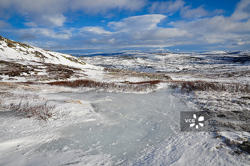 冬日山景：寒风凛冽，蓝天白云，冰雪覆盖图片素材