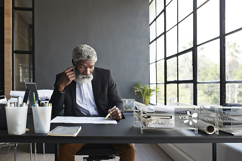 沉思的商务人士在办公桌前工作图片素材