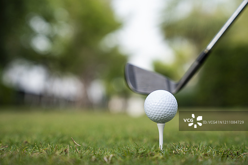 在高尔夫球场日落时打高尔夫球的商人图片素材