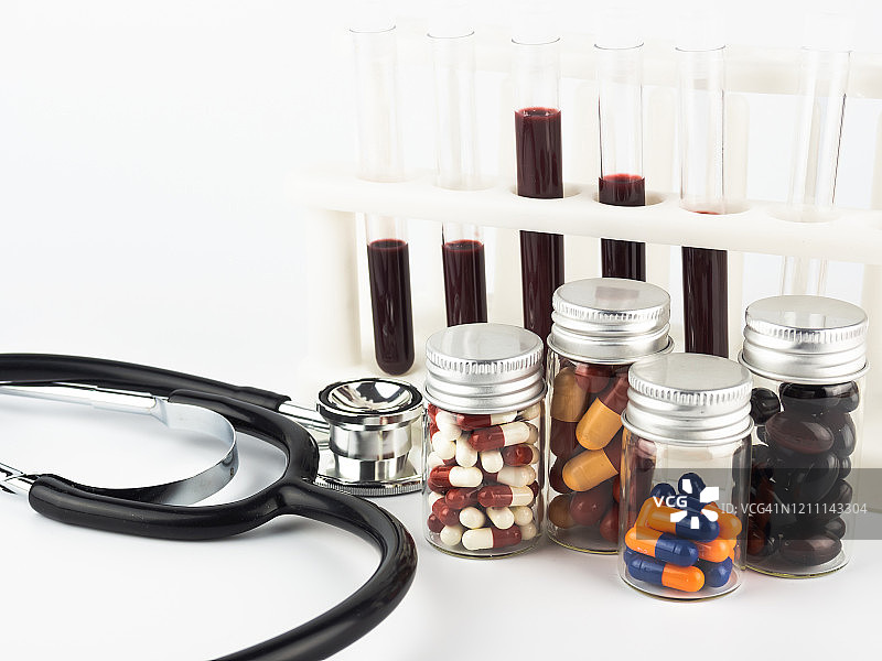 听诊器、药丸罐和带有血液样本的试管在医学实验室中图片素材