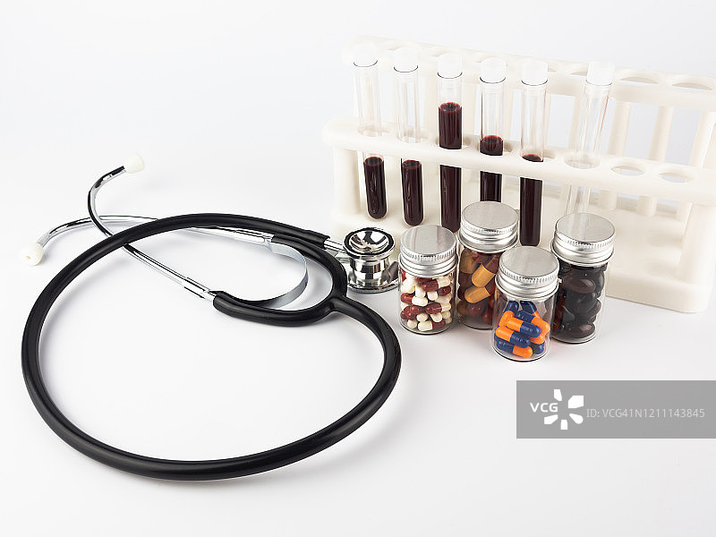 听诊器、药丸罐和带有血液样本的试管在医学实验室中图片素材