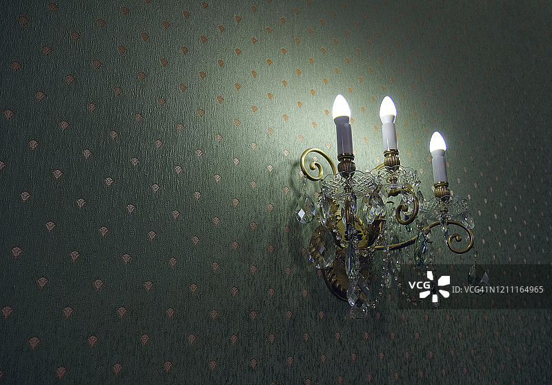 墙上的经典水晶壁灯，绿色壁纸背景图片素材