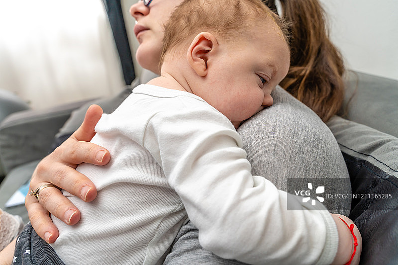 母亲轻拍男婴的背部以使其打嗝图片素材