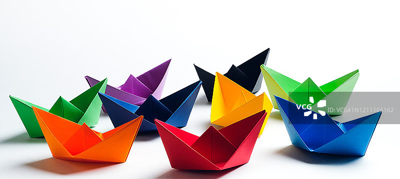 白色背景上的明亮彩色纸船，留白图片素材