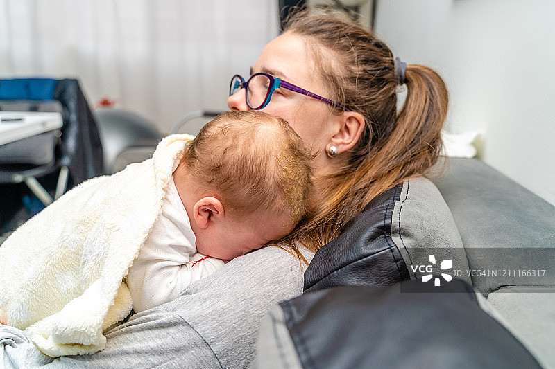 母亲在家抱着患有脂溢性皮炎的新生儿图片素材
