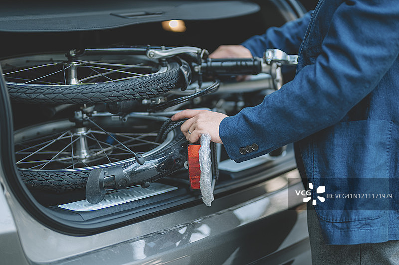 携带折叠自行车通勤的亚洲华人白领图片素材