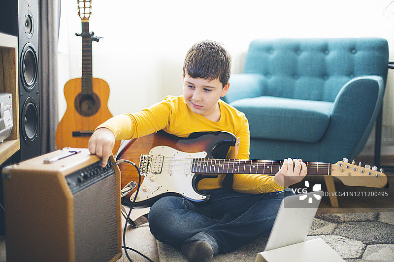 在家弹电子吉他的小男孩图片素材