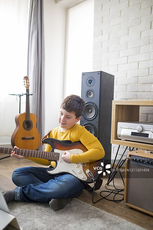 在家弹电子吉他的小男孩图片素材