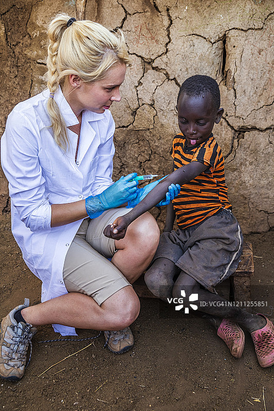 医生在肯尼亚小村庄为非洲男孩注射图片素材