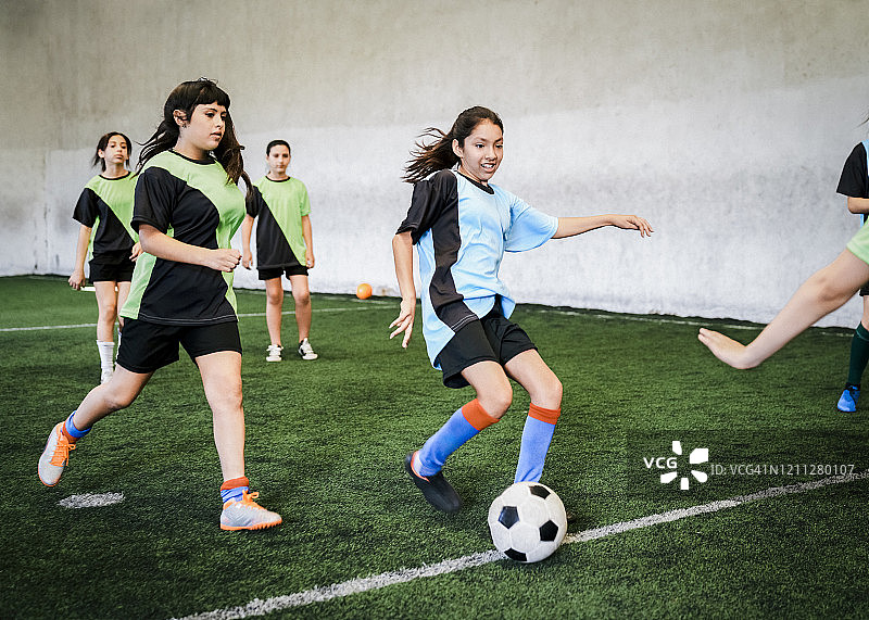 女孩们在运动场上进行足球比赛图片素材