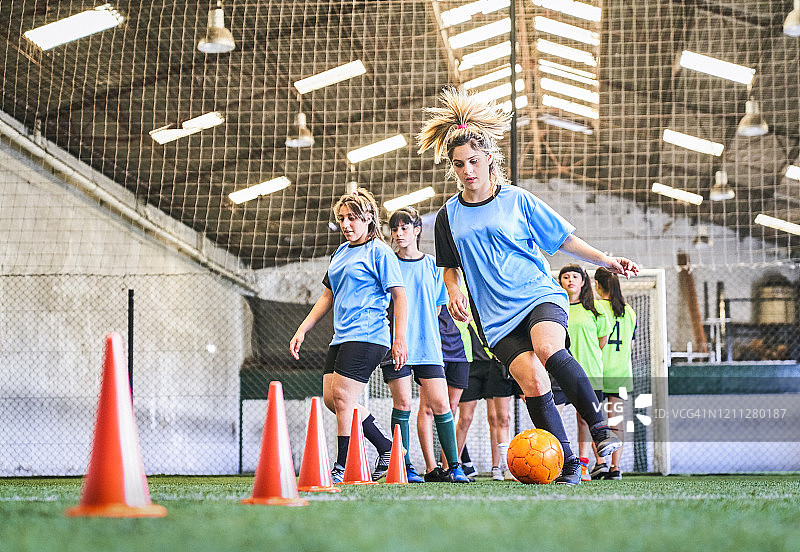 球场上练习足球技巧的女孩图片素材