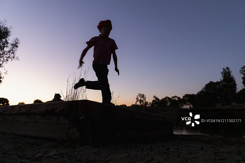 在暮光下奔跑的男孩轮廓图片素材