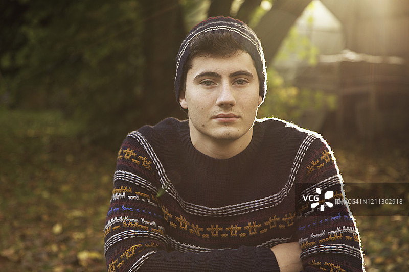 秋日公园里戴着毛衣和针织帽的自信青少年男孩肖像图片素材