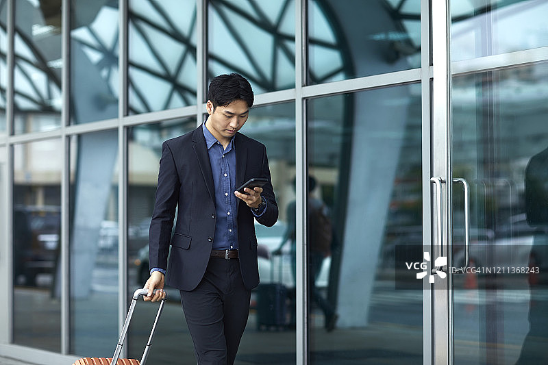 抵达机场时使用手机的商人图片素材