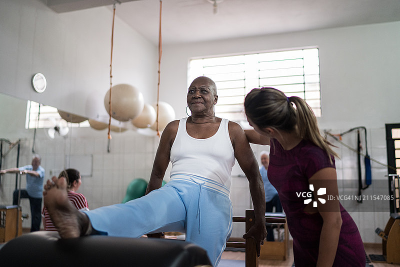 教练为老年妇女进行物理治疗图片素材