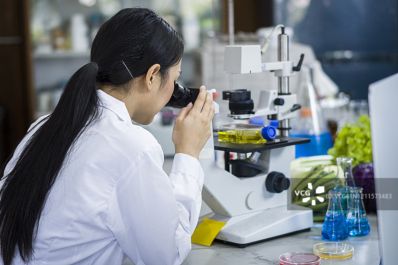 女微生物学家在实验室使用显微镜图片素材
