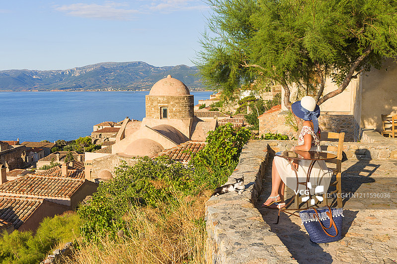 年轻女人欣赏希腊莫奈姆瓦夏中世纪小镇的景色图片素材