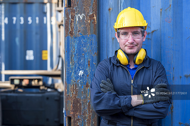 身穿安全防护服站在集装箱前的维修工程师画像图片素材
